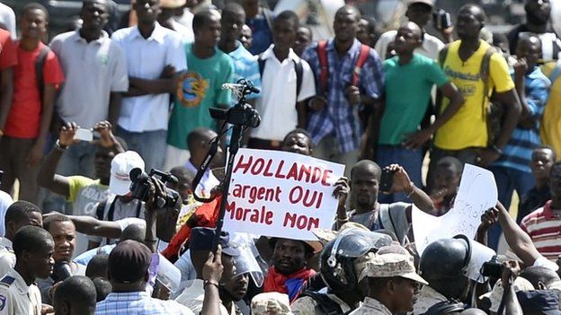 2015, manifestations en réaction à la venue de François Hollande en Haïti. Ce dernier a affirmé que la France a une "dette morale" envers Haïti. 